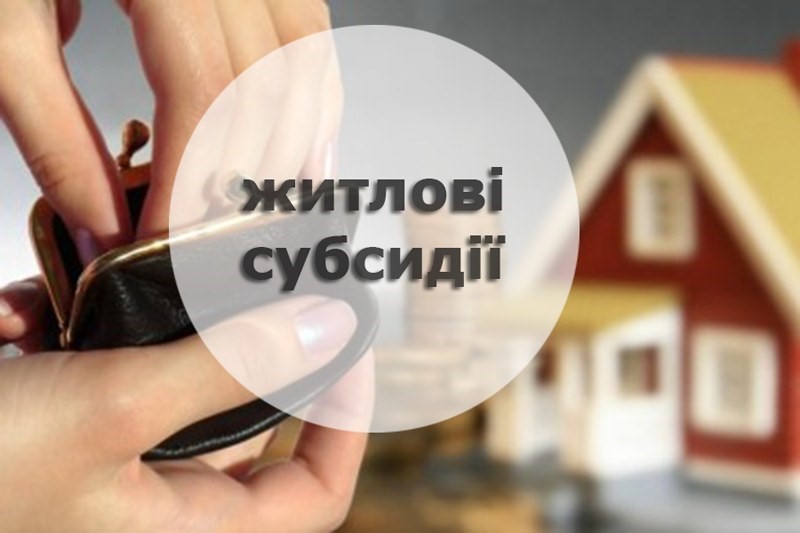 Руки, які тримають гаманець. На передньому плані розміщене коло з написом «Житлові субсидії». На задньому плані розмито зображений будинок, що символізує тему субсидій на оплату житла.