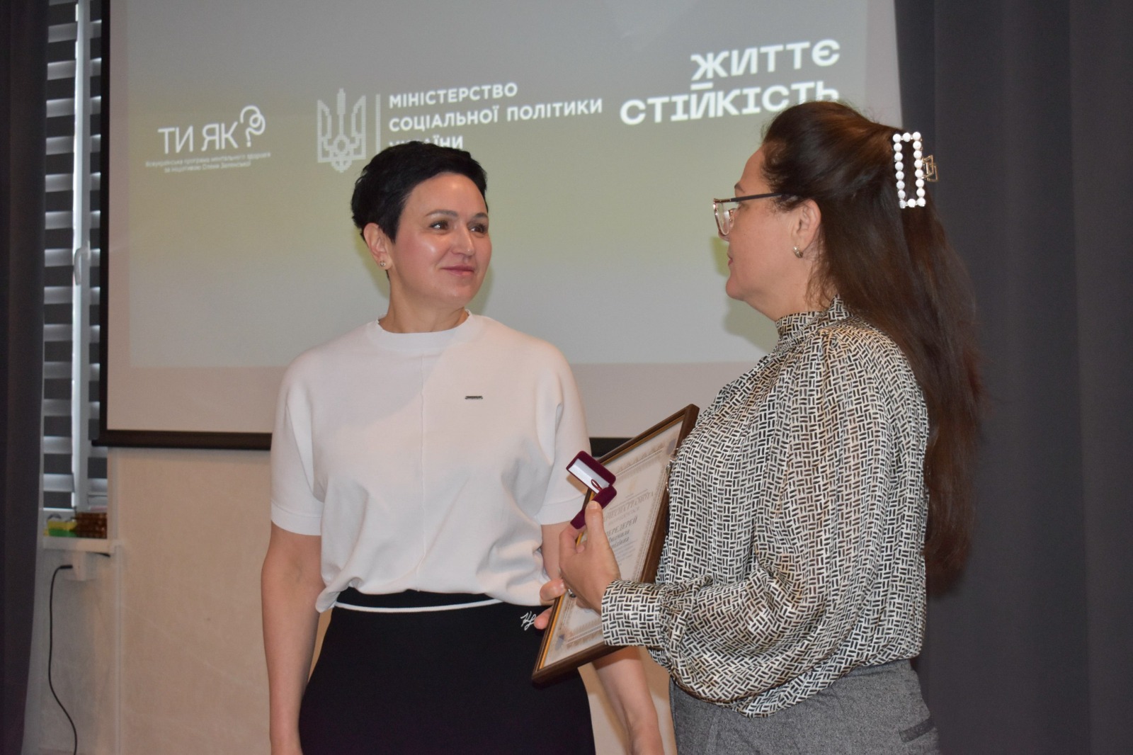 Зустріч на тему «Партнерство з громадою у сфері ментального здоров’я: як залучати, активізувати, підтримувати». Заступниця голови Рівненської ОДА Людмила Шатковська вручає  консультантці Мінсоцполітики Людмилі Передерей почесну грамоту та пам'ятний значок Рівненської облдержадміністрації