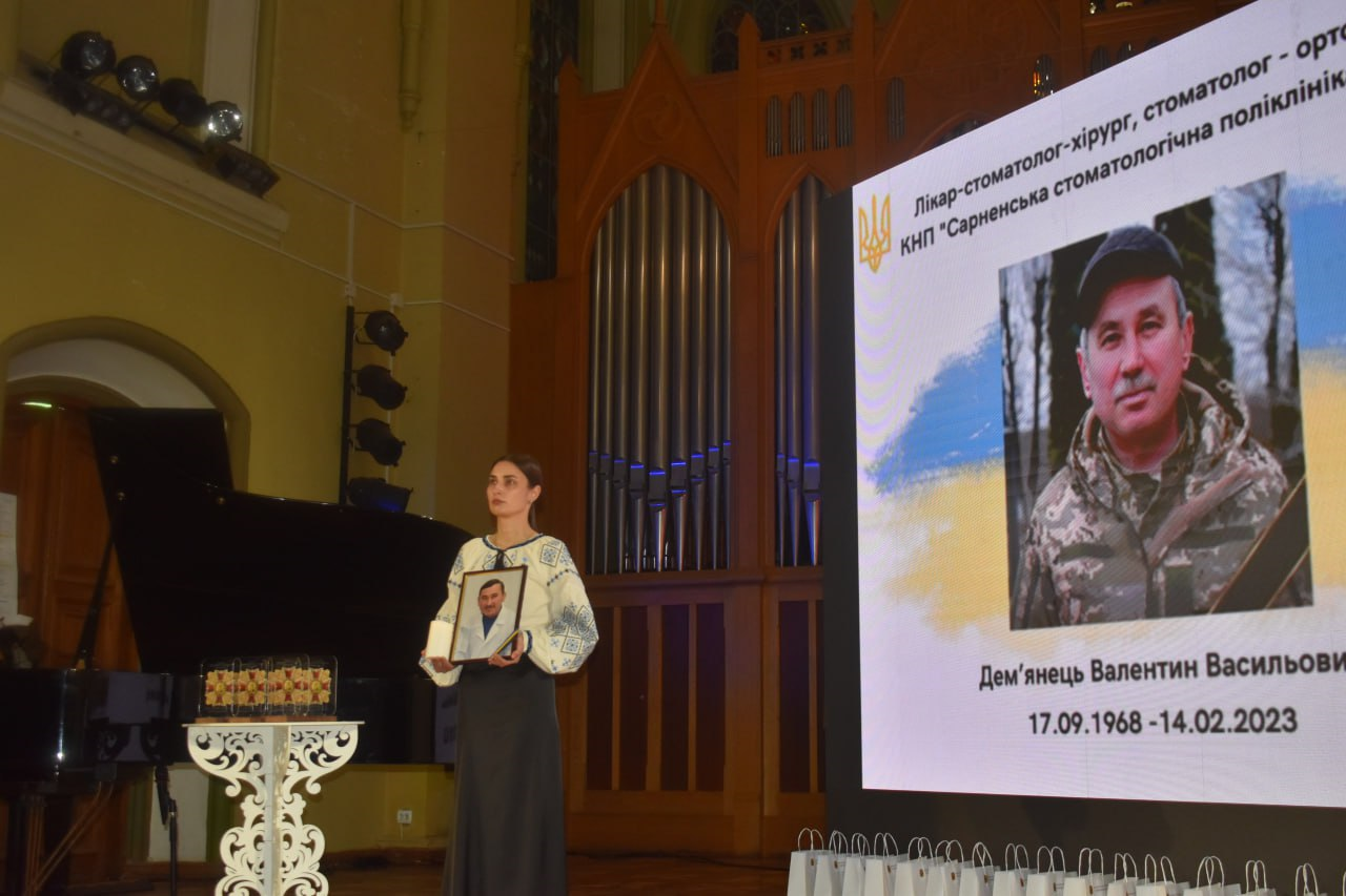Дружина полеглого медика тримає його портрет